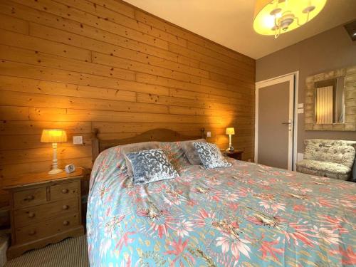 - une chambre avec un lit et un mur en bois dans l'établissement Maison élégante avec jardin et terrasse, WIFI au centre de Perros-Guirec - FR-1-368-455, à Perros-Guirec