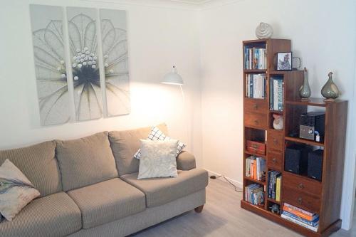 a living room with a couch and a book shelf at Mollys Farm in Dorroughby