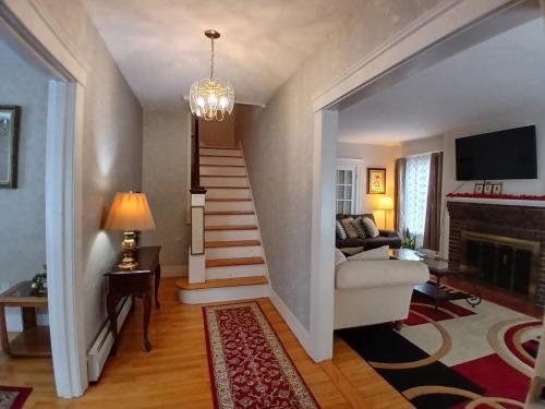a living room with a staircase with a couch and a fireplace at Velocity Residence in Worcester
