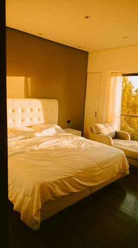 a bedroom with a large white bed and a window at Al Bader Resort in Jurf ad Darāwīsh
