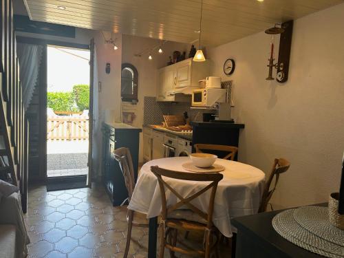 une cuisine avec une table et un chiffon de table blanc dans l'établissement Villa T3 Mezzanine 6P Centre Saint-Cyprien, Proche Plage et Port - FR-1-793-26, à Saint-Cyprien