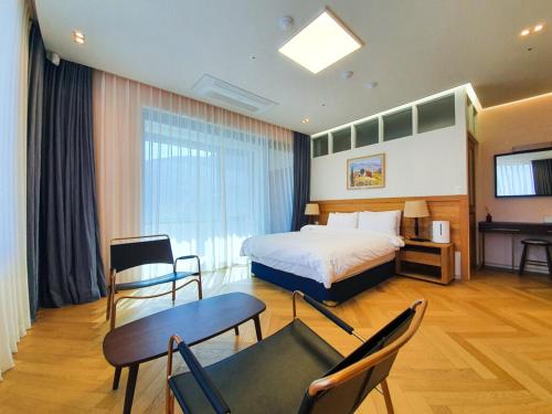 a hotel room with a bed and a table and chairs at Romyzian Garden Mountain House in Handae-dong