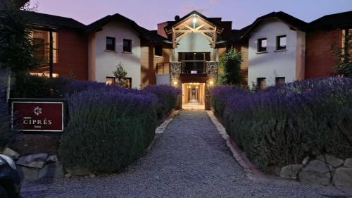 a house with purple flowers in front of it at Atardecer en la Estepa in Dina Huapi