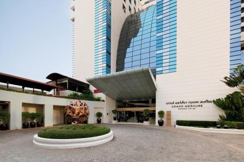 a building with a sculpture in front of it at Grand Mercure Bangkok Atrium in Bangkok