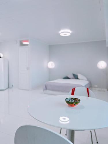 Habitación blanca con mesa, sillas y cama en The White House Helsinki MERIHAKA Private Parking, en Helsinki