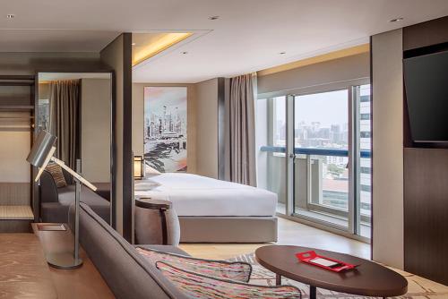 a hotel room with a bed and a tv at Swissotel The Stamford Singapore in Singapore
