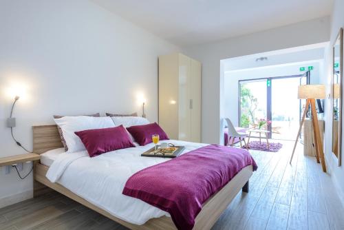 a bedroom with a large bed with a purple blanket at Tandem Apartments with Swimming pool in Cavtat