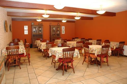 a dining room with tables and chairs and orange walls at Pousada Chablis in Campos do Jordão