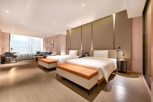 a hotel room with two beds and a desk at Atour Hotel Beijing Yizhuang New Town Majuqiao in Daxing