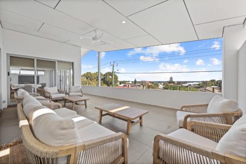 a room with chairs and tables and a large window at Silver Sands Sanctuary - 6BR Beachside Luxury in Mandurah