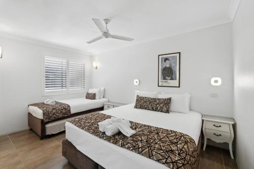 a hotel room with two beds and a couch at Smugglers On The Beach in Coffs Harbour