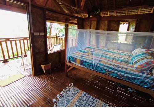a bedroom with a bed in a wooden house at Busuanga Nature Retreat in Busuanga