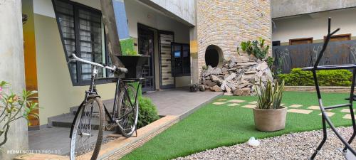 a bike parked in front of a house with grass at OLA LUXURY HOTEL Parakou in Parakou