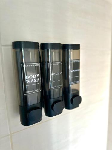 three black cups sitting on a shelf in a bathroom at KERA STAY - Apartments Merseburg in Merseburg