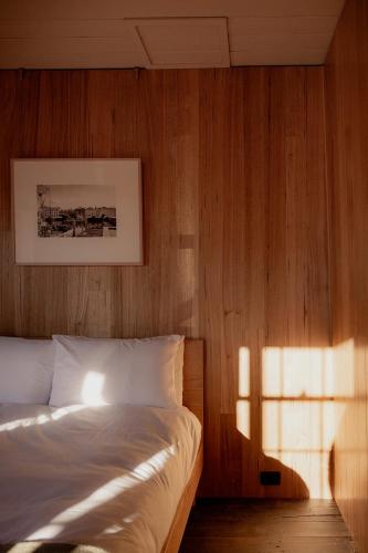 a bedroom with a bed with a wooden wall at Richmond 1823 in Richmond