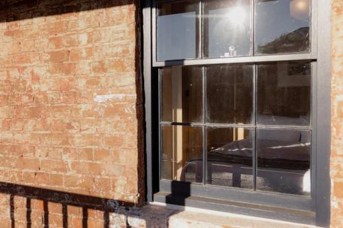 a window of a brick building with a reflection in it at Richmond 1823 in Richmond