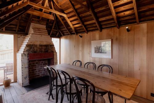 a wooden table and chairs in a room with a fireplace at Richmond 1823 in Richmond