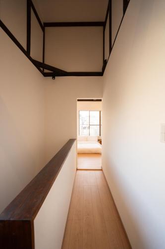 a room with white walls and a wooden table at one stay 一宿 in Nagoya