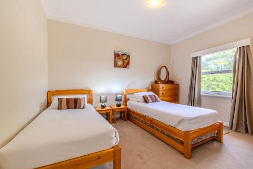 a bedroom with two beds and a window at Acacia Grove by the BnB Collection in Emu Point