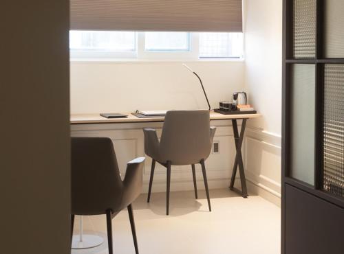 an office with a desk and two chairs and a table at Hotel Gaden in Suwon