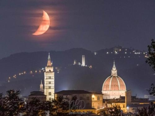 a waning moon rises over a city at night at Beautiful vacation home in San Marcello Pistoiese