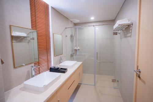 a white bathroom with a sink and a shower at Mey Mansion Hotel Phu Quoc in Phu Quoc