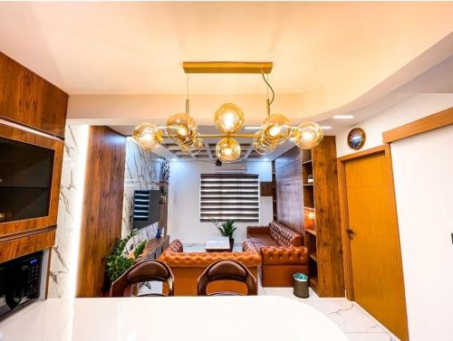 ein Esszimmer mit Tisch und Stühlen und einem Kronleuchter in der Unterkunft The Pink Luxe Apartment in Thiruvananthapuram