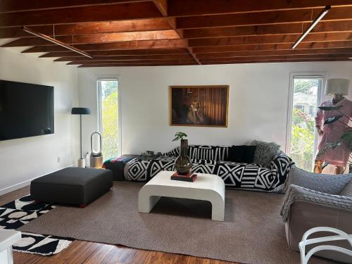 a living room with a couch and a table at Spacious Resort Getaway @ Echo Park Ranch - Luxury indoor/ outdoor home steps from Sunset Blvd, Echo Park Lake, Dodgers Stadium in Los Angeles