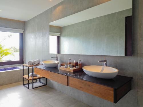 a bathroom with two sinks and a large mirror at The Samata by LifestyleRetreats in Sanur