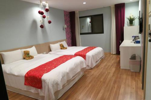 a hotel room with two beds with teddy bears on them at 茶源旅店-潭暉魚池館 in Yuchi