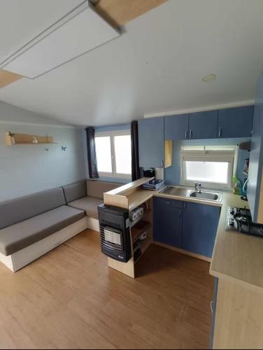 une petite cuisine avec un canapé et un évier dans l'établissement Mobil home tout confort, à La Celle-sous-Gouzon