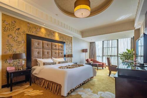 a bedroom with a large bed and a living room at Sichuan Tennis International Hotel Main Building in Chengdu