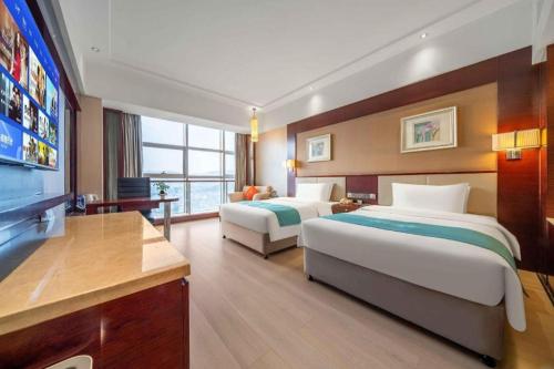 a hotel room with two beds and a flat screen tv at Xiangsheng Century Hotel Zhuji in Shaoxing