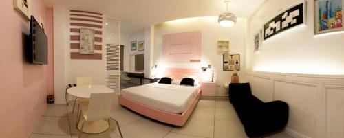a bedroom with a bed and a table and a desk at Hotel Monde in Dagupan