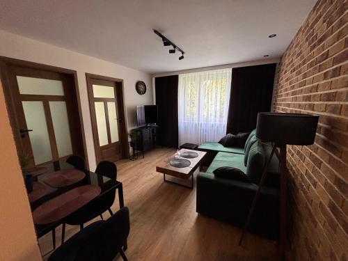 a living room with a green couch and a brick wall at Biała Centrum 2 in Biała Podlaska