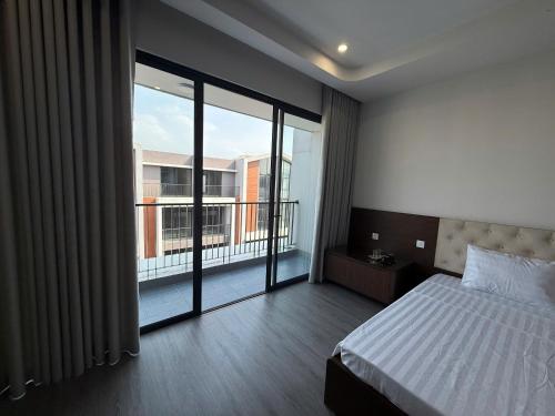 a bedroom with a bed and a view of a balcony at Phố Biển Homestay & Apartment in Ðình Loan