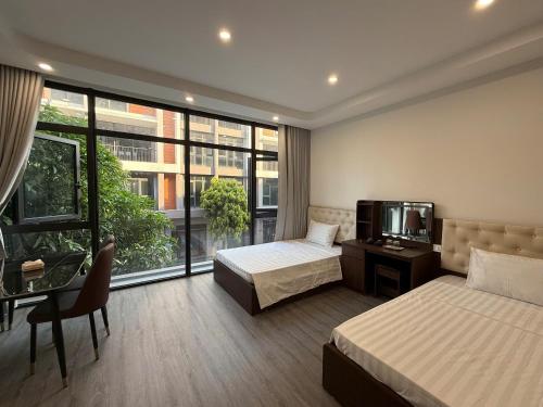 a hotel room with two beds and a television at Phố Biển Homestay & Apartment in Ðình Loan