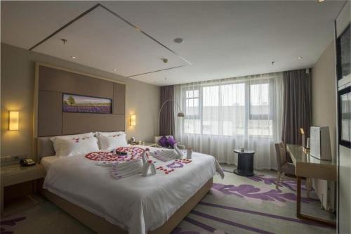 Una habitación de hotel con una cama grande y un escritorio. en Lavande Hotel Jinan Quancheng Road Baotu Spring Branch, en Jinan