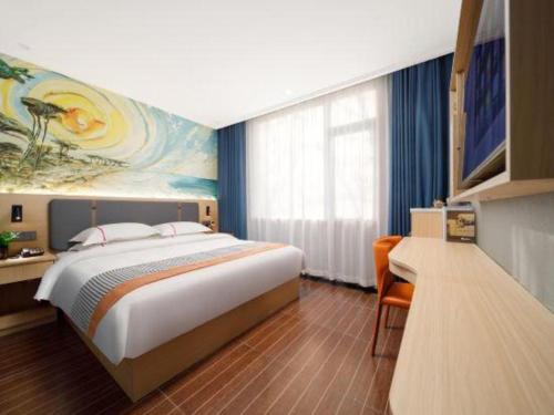 a bedroom with a large bed and a painting on the wall at JIAN AI XI YUE HOTEL in Yiwu