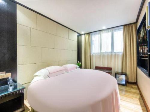 a large white bed in a room with a window at JIAN AI XI YUE HOTEL in Yiwu