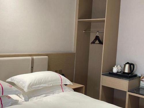 a hotel room with a bed and a coffee pot on a shelf at JIAN AI XI YUE HOTEL in Yiwu