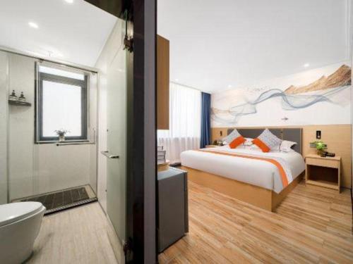 a bedroom with a bed and a bathroom with a tub at JIAN AI XI YUE HOTEL in Yiwu