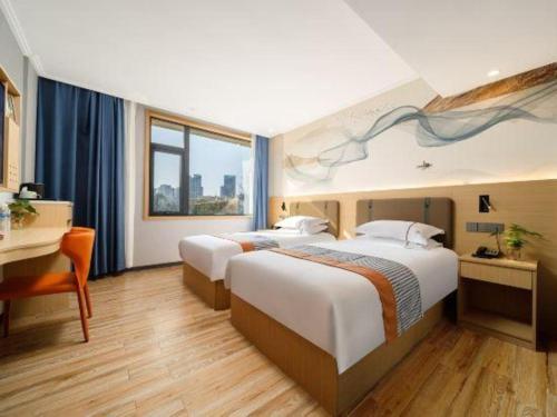 a hotel room with two beds and a desk at JIAN AI XI YUE HOTEL in Yiwu