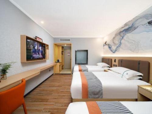 a hotel room with two beds and a flat screen tv at JIAN AI XI YUE HOTEL in Yiwu