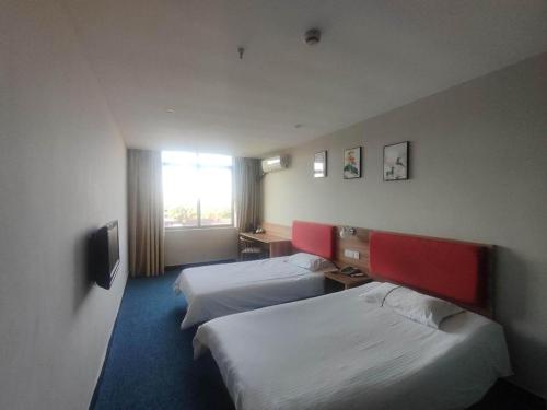 a hotel room with two beds and a window at Shanghai Jiejia hotel in Shanghai