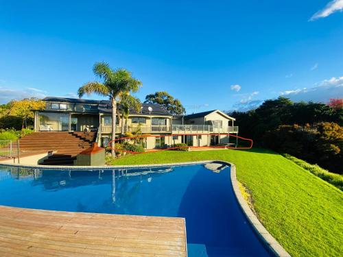 a house with a swimming pool in front of it at Peninsula Paradise in Tauranga