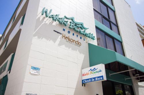 a building with a sign on the side of it at Waikiki Beachside Hostel in Honolulu