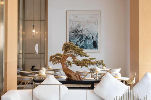 a bonsai tree sitting on a table in a restaurant at Amanda Hotel堆谷里酒店 in Phnom Penh