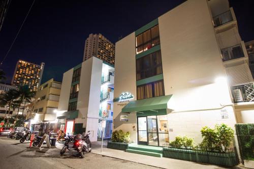 a building with motorcycles parked in front of it at Waikiki Beachside Hostel in Honolulu