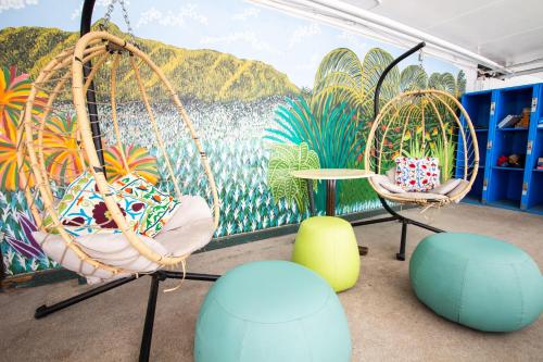 a room with two swinging chairs and a mural at Waikiki Beachside Hostel in Honolulu